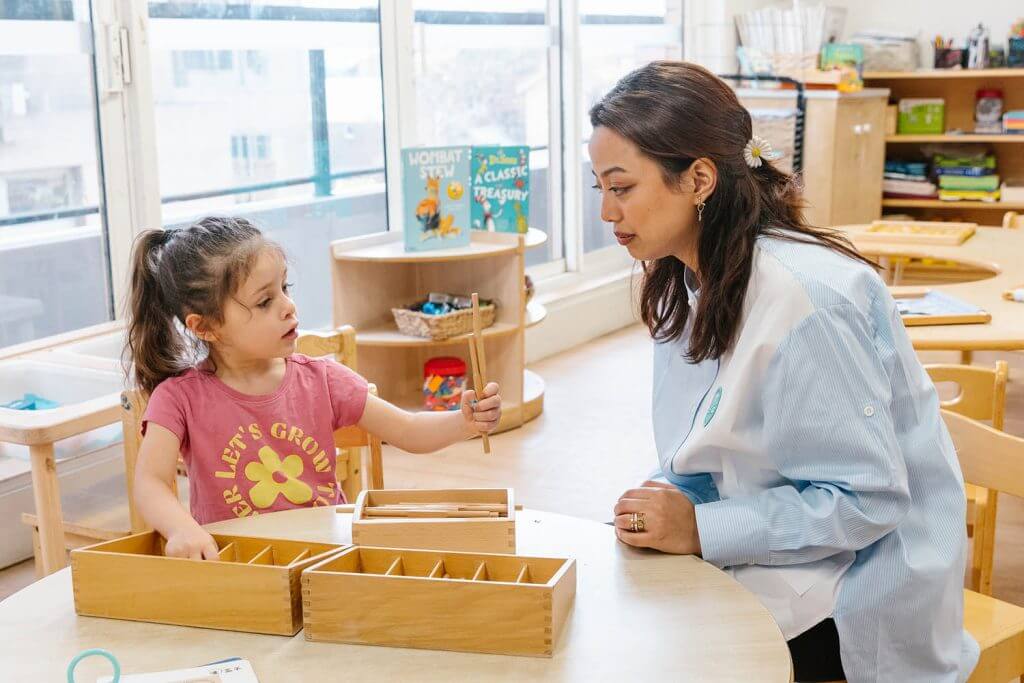 Educator at Wonder Garden Learning Center guiding a small group of children during a learning activity